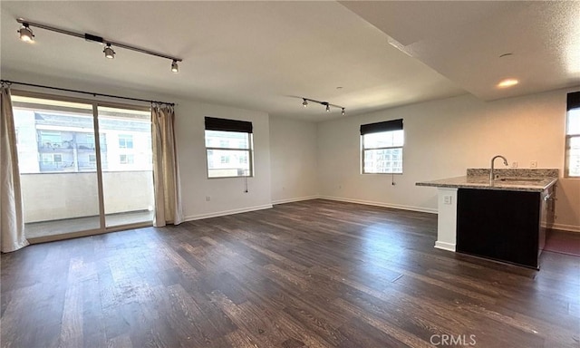 612 E Carson St Unit 303, Carson, CA 90745 - unfurnished living room with track lighting, dark wood-style floors, and plenty of natural light