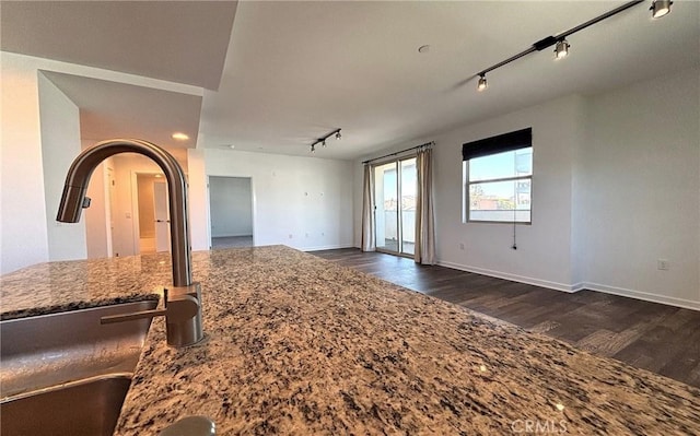 612 E Carson St Unit 303, Carson, CA 90745 - unfurnished living room featuring rail lighting and dark wood-type flooring