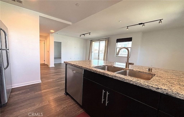 612 E Carson St Unit 303, Carson, CA 90745 - kitchen featuring stainless steel appliances, rail lighting, dark wood finished floors, dark cabinetry, and light stone counters