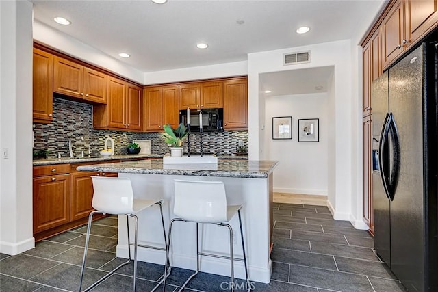 5410 W 149th Pl Unit 12, Hawthorne, CA 90250 - kitchen featuring black appliances, backsplash, brown cabinets, a kitchen island, and recessed lighting