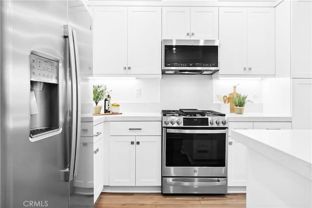 112 Juniper Dr, Rancho Mission Viejo, CA 92694 - kitchen featuring appliances with stainless steel finishes, light countertops, white cabinetry, and light wood-type flooring