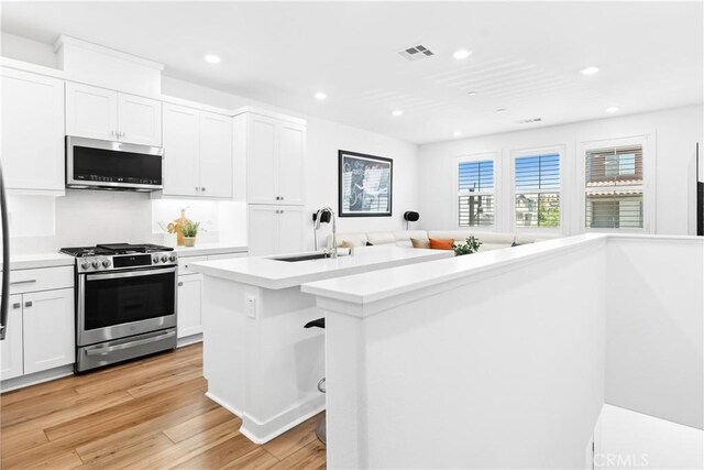 112 Juniper Dr, Rancho Mission Viejo, CA 92694 - kitchen featuring stainless steel appliances, recessed lighting, light wood-type flooring, light countertops, and white cabinetry