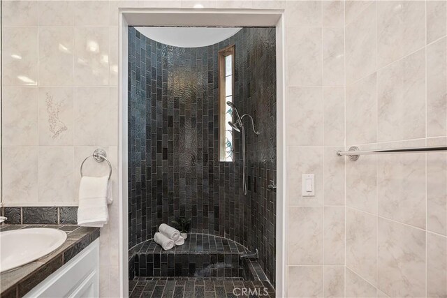 390 Saint Anns Dr, Laguna Beach, CA 92651 - full bathroom with a tile shower, vanity, and tile walls