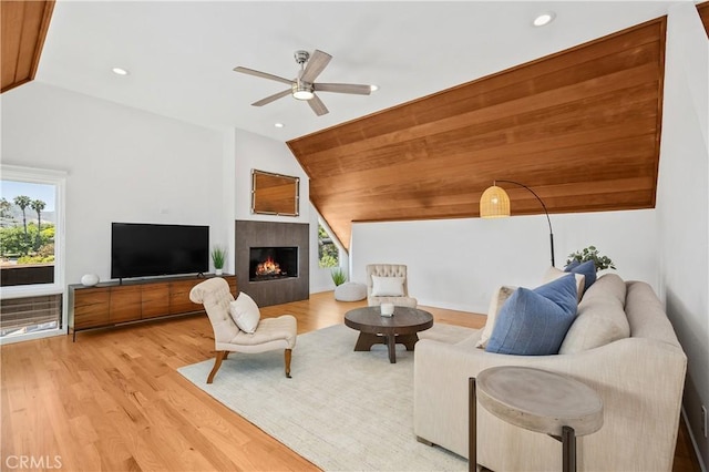 390 Saint Anns Dr, Laguna Beach, CA 92651 - living area with vaulted ceiling, healthy amount of natural light, light wood finished floors, a ceiling fan, and a warm lit fireplace