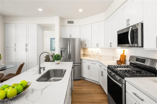 17 Marseille Way, Lake Forest, CA 92610 - kitchen featuring stainless steel appliances, white cabinets, wood finished floors, and recessed lighting