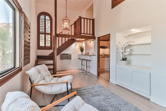 1369 Paseo Redondo, Burbank, CA 91501 - sitting room featuring wood finished floors, a chandelier, stairway, a high ceiling, and an AC wall unit