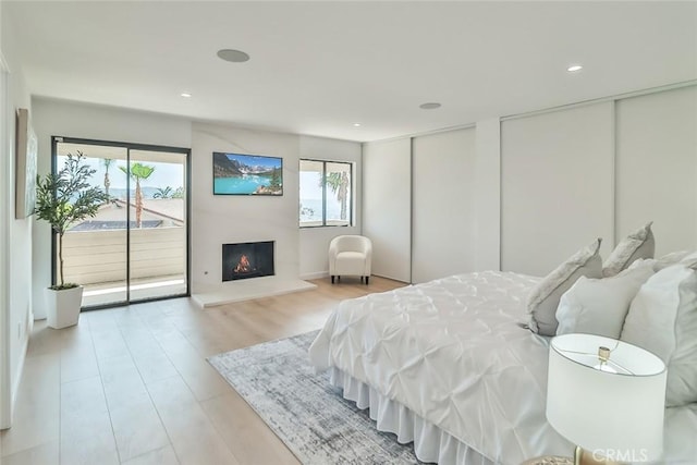 1369 Paseo Redondo, Burbank, CA 91501 - bedroom with access to outside, two closets, a warm lit fireplace, light wood finished floors, and recessed lighting