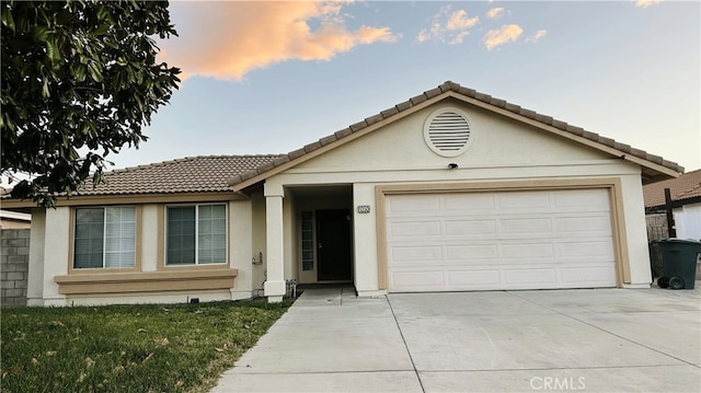 1350 William Mcgrath St, Colton, CA 92324 - ranch-style house with driveway, a tiled roof, stucco siding, and an attached garage
