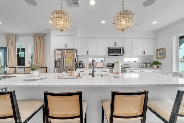 516 Caleigh Ln, Costa Mesa, CA 92627 - kitchen featuring stainless steel appliances, a chandelier, white cabinets, pendant lighting, and recessed lighting