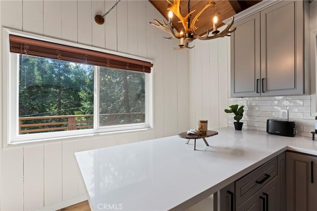 698 W Victoria Ct, Lake Arrowhead, CA 92352 - kitchen with a chandelier, light countertops, hanging light fixtures, gray cabinets, and backsplash