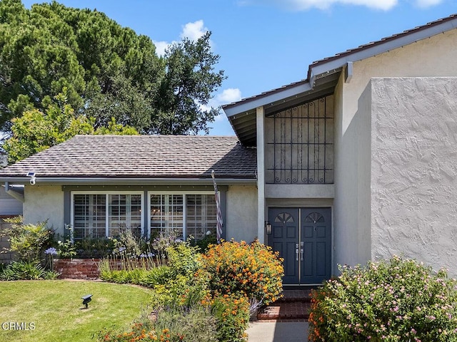 18845 Braemore Rd, Porter Ranch, CA 91326 - view of exterior entry with stucco siding and a lawn
