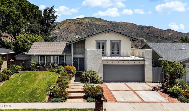 18845 Braemore Rd, Porter Ranch, CA 91326 - view of front of house featuring stucco siding, driveway, a balcony, and a mountain view