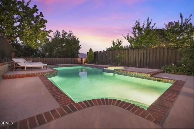 18845 Braemore Rd, Porter Ranch, CA 91326 - pool at dusk with a fenced backyard, an in-ground hot tub, and a patio area