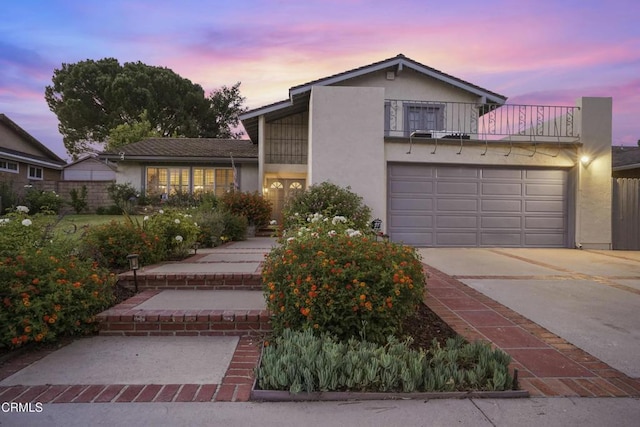 18845 Braemore Rd, Porter Ranch, CA 91326 - view of front of house featuring a balcony, stucco siding, driveway, and a garage