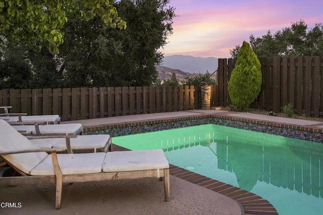 18845 Braemore Rd, Porter Ranch, CA 91326 - pool at dusk featuring a mountain view and a fenced backyard