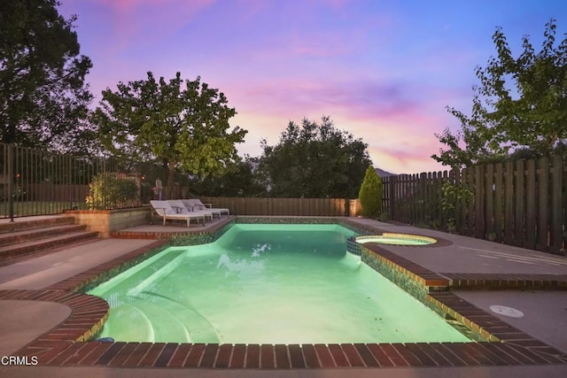 18845 Braemore Rd, Porter Ranch, CA 91326 - pool at dusk with a patio area, a fenced backyard, and a pool with connected hot tub