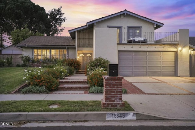 18845 Braemore Rd, Porter Ranch, CA 91326 - view of front of home with a balcony, stucco siding, concrete driveway, a front yard, and an attached garage