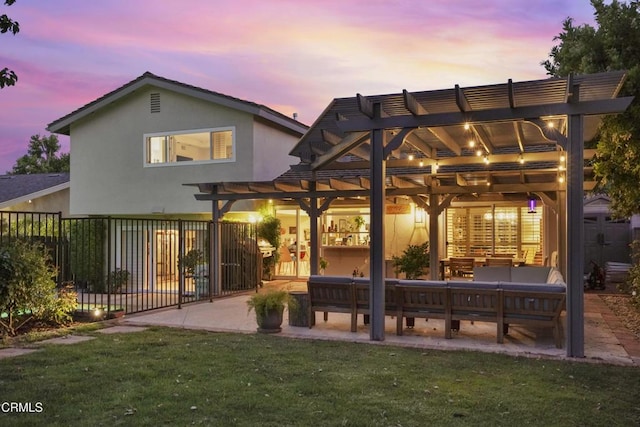 18845 Braemore Rd, Porter Ranch, CA 91326 - back of house at dusk with a pergola, a patio area, stucco siding, and an outdoor living space