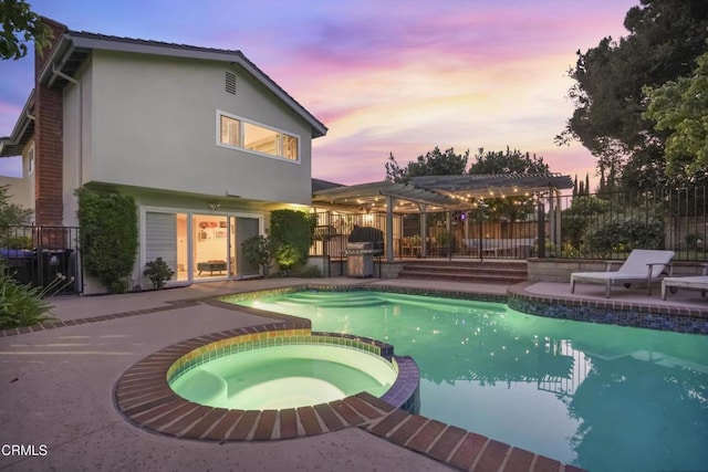 18845 Braemore Rd, Porter Ranch, CA 91326 - pool at dusk with a pergola, a pool with connected hot tub, a patio area, and a grill