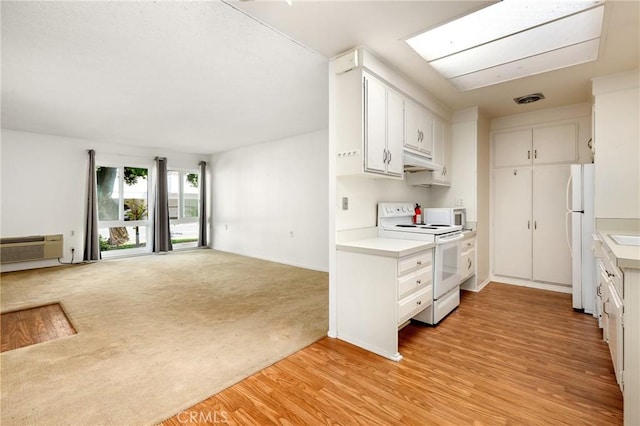 2179 Via Puerta Unit R, Laguna Woods, CA 92637 - kitchen with white appliances, under cabinet range hood, light countertops, and white cabinets