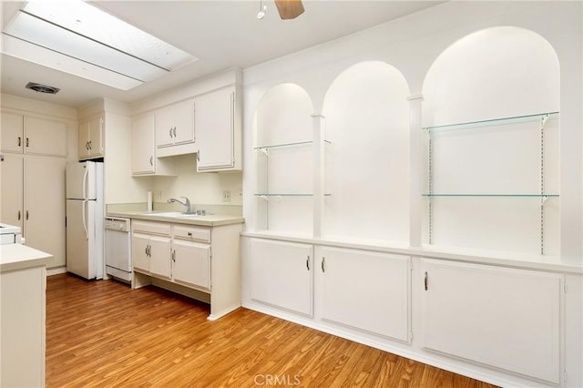 2179 Via Puerta Unit R, Laguna Woods, CA 92637 - kitchen featuring white appliances, light wood-type flooring, light countertops, white cabinetry, and ceiling fan
