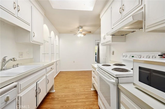 2179 Via Puerta Unit R, Laguna Woods, CA 92637 - kitchen with electric stove, under cabinet range hood, light countertops, light wood finished floors, and white cabinets