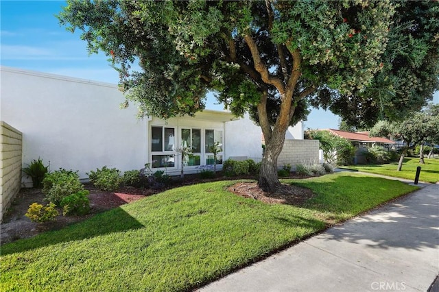 2179 Via Puerta Unit R, Laguna Woods, CA 92637 - view of front of house featuring a front lawn and stucco siding