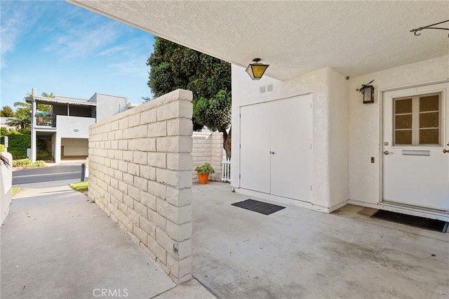 2179 Via Puerta Unit R, Laguna Woods, CA 92637 - view of exterior entry with stucco siding and a patio