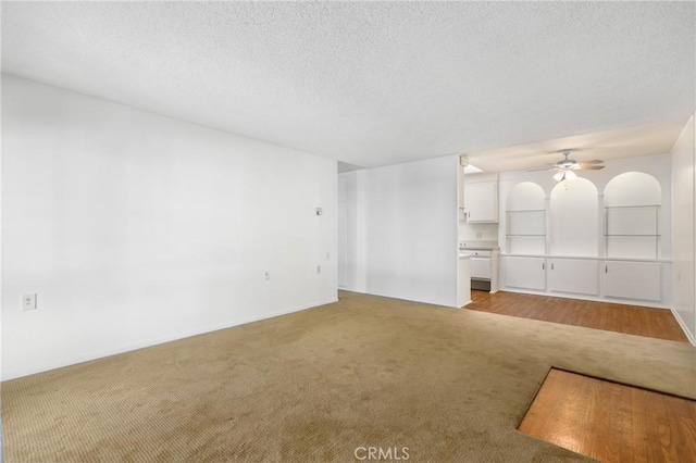 2179 Via Puerta Unit R, Laguna Woods, CA 92637 - unfurnished living room with light carpet, ceiling fan, and a textured ceiling