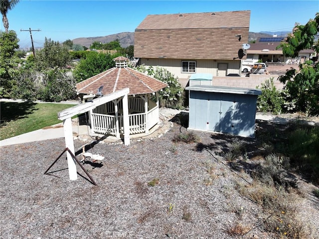 35632 Avocado St, Yucaipa, CA 92399 - back of house featuring a gazebo, roof with shingles, and a storage unit