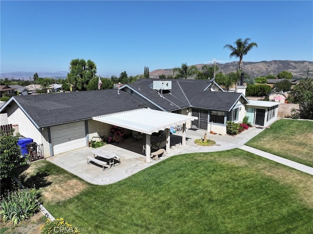 35632 Avocado St, Yucaipa, CA 92399 - back of property with a lawn, a patio area, a mountain view, a sunroom, and stucco siding