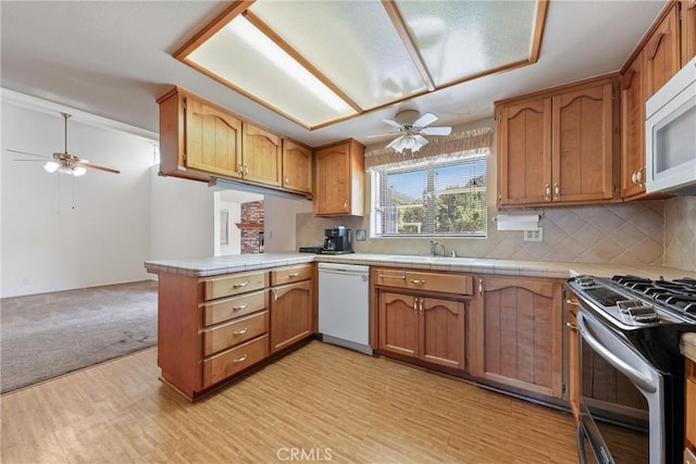 35632 Avocado St, Yucaipa, CA 92399 - kitchen with white appliances, a ceiling fan, a peninsula, and brown cabinets