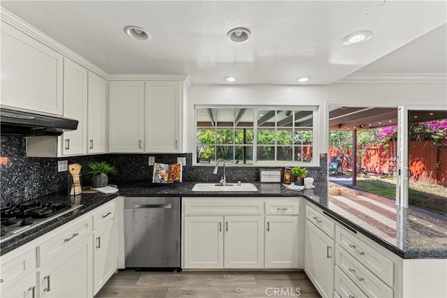 1626 Birchfield Dr, Tustin, CA 92780 - kitchen with stainless steel appliances, under cabinet range hood, ornamental molding, white cabinetry, and decorative backsplash