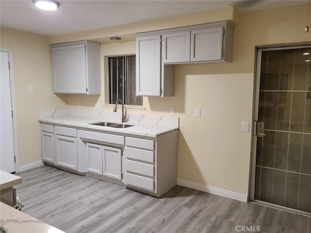 18605 New Hampshire St, Adelanto, CA 92301 - kitchen with light wood-type flooring, gray cabinets, and light stone countertops