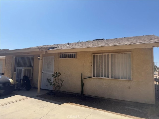 18605 New Hampshire St, Adelanto, CA 92301 - view of front facade with stucco siding, roof with shingles, and a patio
