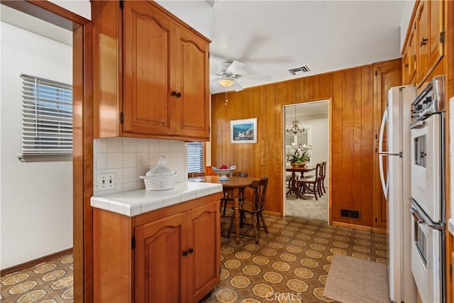 4840 Heleo Ave, Temple City, CA 91780 - kitchen with stainless steel oven, a ceiling fan, backsplash, brown cabinets, and freestanding refrigerator