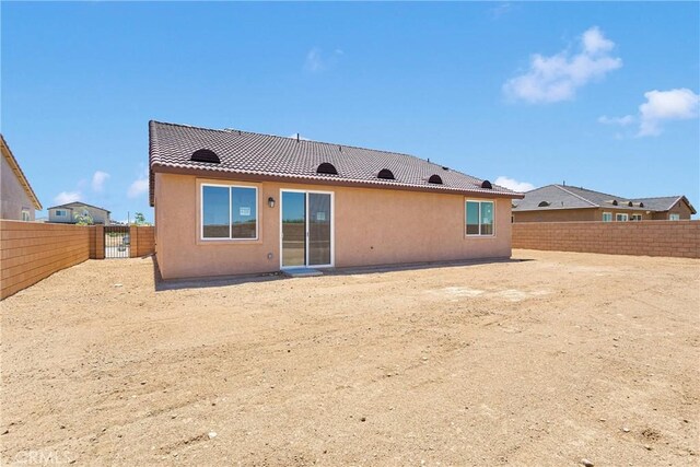16124 Pablo Ct, Victorville, CA 92395 - back of house with a fenced backyard, a tile roof, and stucco siding