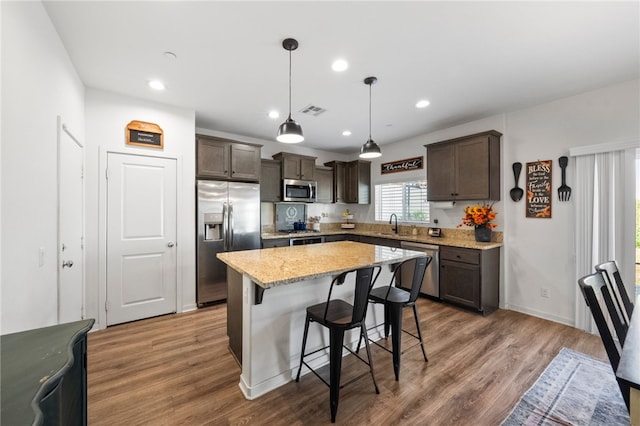 24212 Bay Laurel Ave, Murrieta, CA 92562 - kitchen featuring stainless steel appliances, dark brown cabinetry, a breakfast bar area, light stone countertops, and recessed lighting