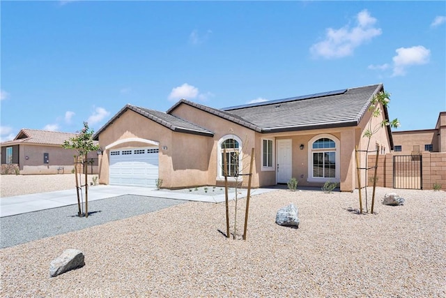 16148 Pablo Ct, Victorville, CA 92395 - view of front facade with roof mounted solar panels, driveway, stucco siding, a garage, and a tiled roof