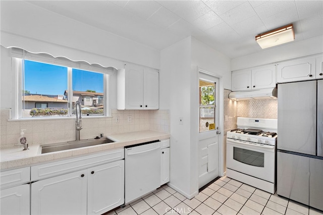 2460 Vuelta Grande Ave, Long Beach, CA 90815 - kitchen featuring white appliances, under cabinet range hood, white cabinetry, and tasteful backsplash