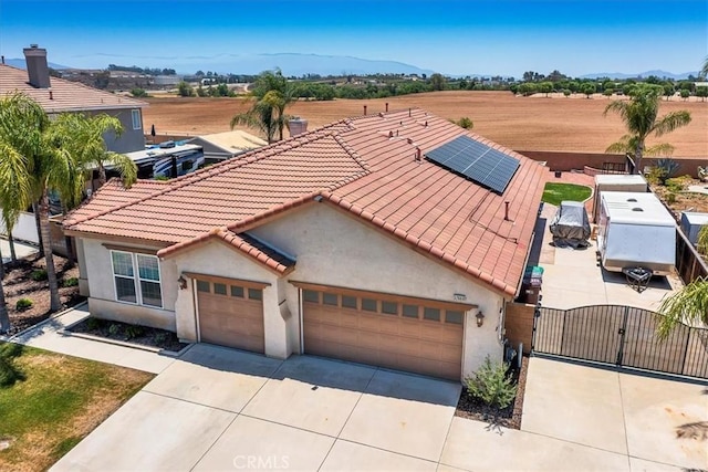 32669 Armoise Dr, Winchester, CA 92596 - view of front of home with a gate, driveway, an attached garage, stucco siding, and roof mounted solar panels