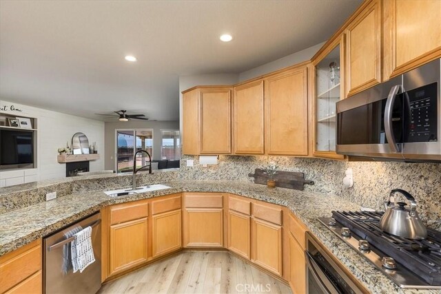 32669 Armoise Dr, Winchester, CA 92596 - kitchen with appliances with stainless steel finishes, light wood finished floors, backsplash, ceiling fan, and glass insert cabinets