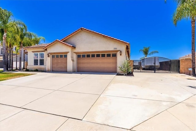 32669 Armoise Dr, Winchester, CA 92596 - mediterranean / spanish home featuring driveway, a garage, stucco siding, a gate, and a tiled roof
