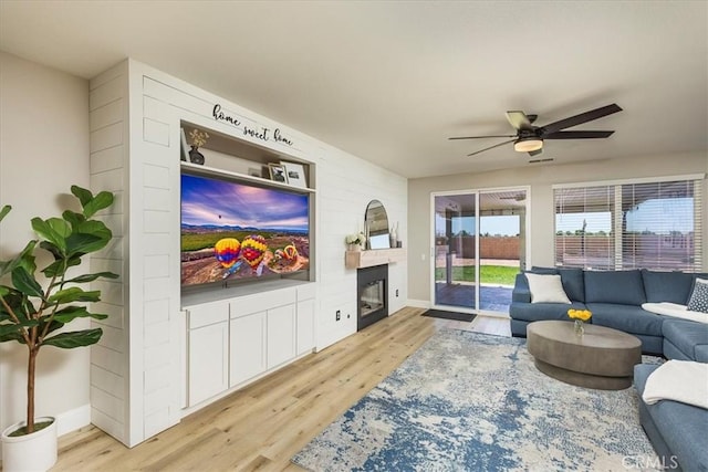32669 Armoise Dr, Winchester, CA 92596 - living area featuring wood finished floors, a ceiling fan, and a glass covered fireplace