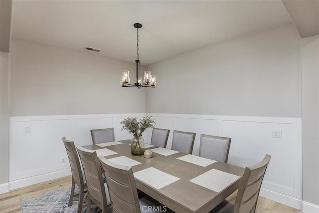 32669 Armoise Dr, Winchester, CA 92596 - dining space with a chandelier, light wood-type flooring, a decorative wall, and wainscoting