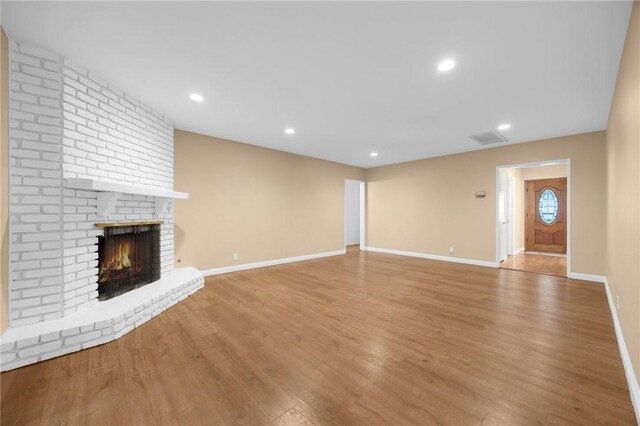 4159 Redline Dr, Lakewood, CA 90713 - unfurnished living room with wood finished floors, a brick fireplace, and recessed lighting