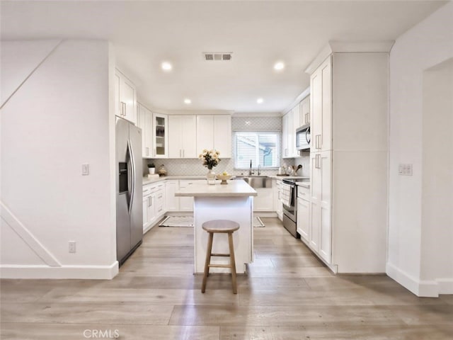5435 W 76th St, Los Angeles, CA 90045 - kitchen featuring appliances with stainless steel finishes, a kitchen island, light wood finished floors, backsplash, and recessed lighting