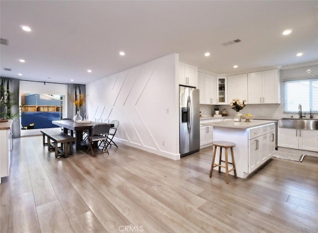 5435 W 76th St, Los Angeles, CA 90045 - kitchen featuring stainless steel fridge, light wood-style flooring, white cabinetry, a kitchen island, and recessed lighting