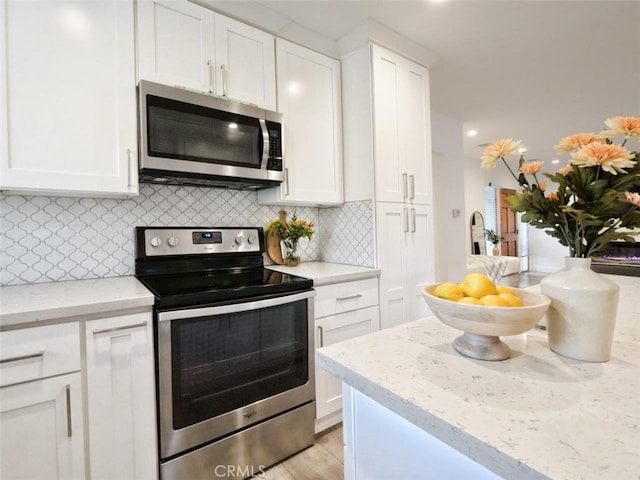 5435 W 76th St, Los Angeles, CA 90045 - kitchen featuring stainless steel appliances, white cabinets, backsplash, light stone countertops, and light wood-type flooring