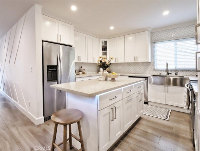 5435 W 76th St, Los Angeles, CA 90045 - kitchen featuring stainless steel appliances, decorative backsplash, white cabinets, a kitchen island, and recessed lighting